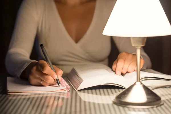 Mujer está estudiando y tomar notas tarde en la noche —  Fotos de Stock