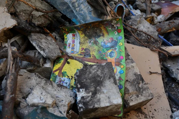 KYIV, UKRAINE - HAZİRAN 02, 2022: Rus füzelerinin çarpması ve patlaması sonucu yüksek binaların yıkıntıları arasında yer alan bir çocuk kitabı. Rusya Ukrayna 'ya askeri saldırısına devam ediyor