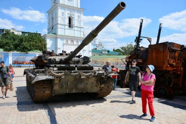 Yoldan geçenler, Kyiv 'in merkezinde sergilenen imha edilmiş Rus T-72 tankına bakın.