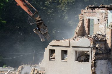 BUCHA, UKRAINE - 16 Haziran 2022: İnşaat ekipmanları, bir Rus füzesi tarafından yıkılan yıkılan binanın yük taşıyan yapılarını söküyor. Rusya Ukrayna 'ya askeri saldırısına devam ediyor