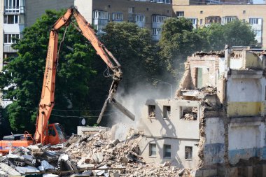 BUCHA, UKRAINE - 16 Haziran 2022: İnşaat ekipmanları, bir Rus füzesi tarafından yıkılan yıkılan binanın yük taşıyan yapılarını söküyor. Rusya Ukrayna 'ya askeri saldırısına devam ediyor