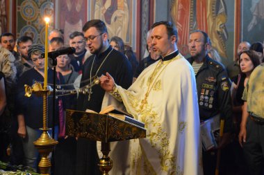 21 Temmuz 2022 Pazartesi günü Ukrayna 'nın başkenti Kyiv' deki Aziz Michael Katedrali 'nde düzenlenen törende Rus kuvvetleri tarafından öldürülen bir asker olan Karim Gulamov' un tabutunda dua okuyan bir rahip görülüyor..