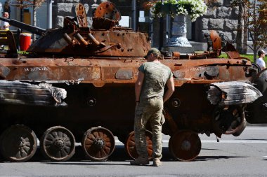 KYIV, UKRAINE - August  21, 2022: Man in military uniform inspect the destroyed Russian army equipment displayed at Khreshchatyk in the center of Kyiv.