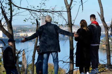 10 Ekim 2022 'de Rus füzeleri Ukrayna' nın başkenti Kyiv 'i vurduktan sonra insanlar yaya köprüsüne ve yanmış ağaçlara bakıyorlar..