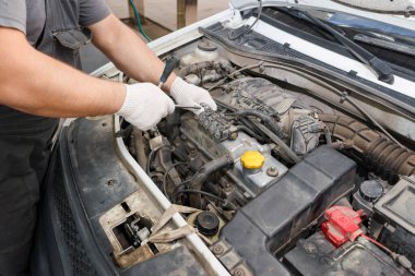 Aracın teknisyeni motor tamir ediyor. Profesyonel tamirci motor arızasını kontrol ediyor.