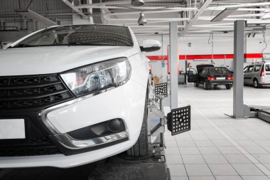 Araba tekerleklerinin elektronik ayarı. Lastik, garajda hizalanan otomatik tekerlek hizasına kenetlendi. Arabanın elektronik ayarı var. Modern atölyede profesyonel araba bakımı.