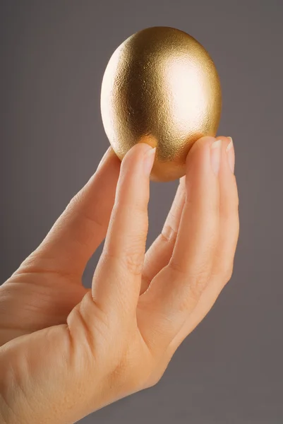 Hand holding golden egg — Stock Photo, Image