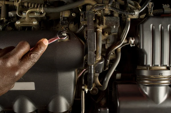 Zuid-Afrikaanse of American mechanische hand met roet vaststelling of het onderhoud van automotoren — Stockfoto