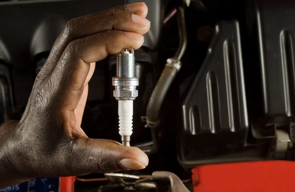 Mechanic and spark plug — Stock Photo, Image