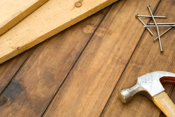 Hammer, nails and plank on table — Stock Photo, Image