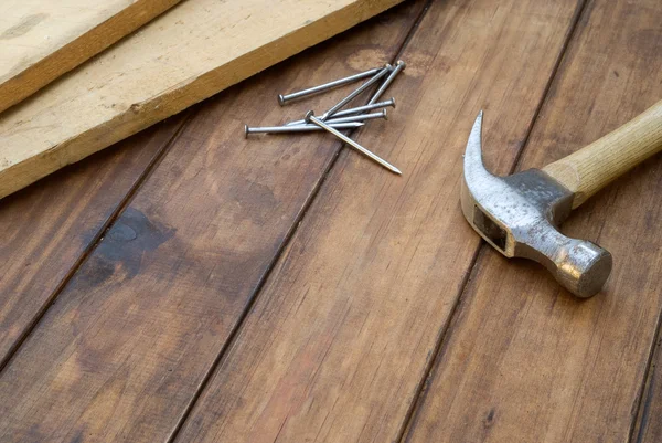 Hamer, spijkers en plank op tafel — Stockfoto