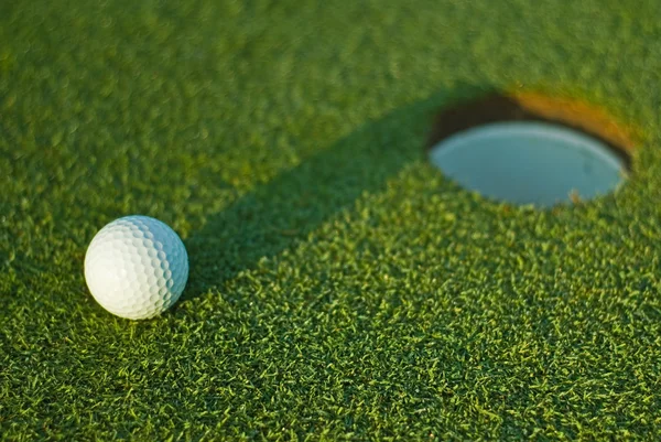 Мяч для гольфа рядом с лункой 1 — стоковое фото
