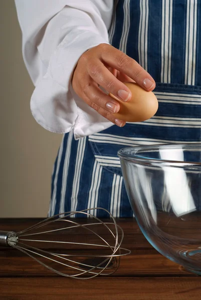 Kobieta kucharz łamanie jajka do miski — Zdjęcie stockowe