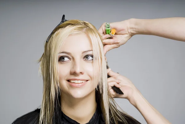 Smiling client while hairdresser cutting hair — Stock Photo, Image