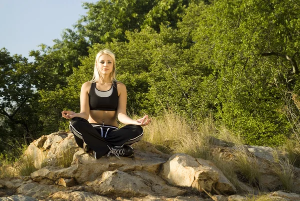 Vrouw mediteren yoga op rots — Stockfoto