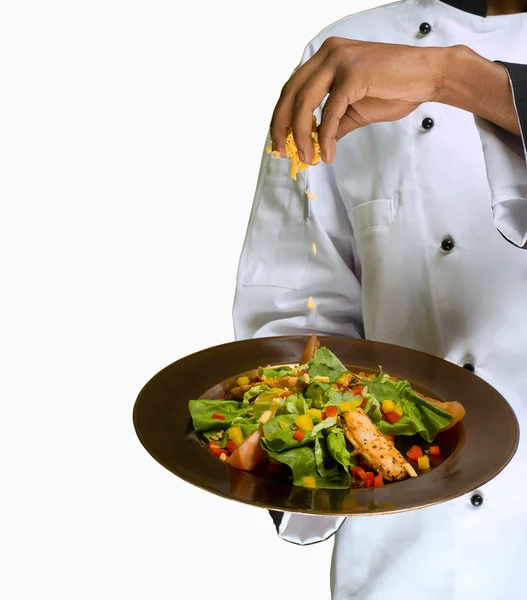 Koch streut Käse auf Salat — Stockfoto