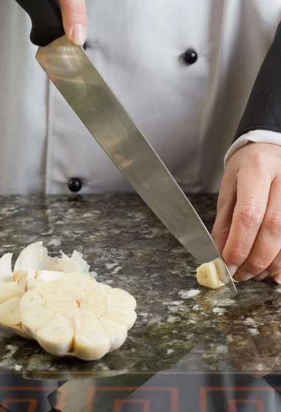 Chef-kok snijden teentje knoflook — Stockfoto