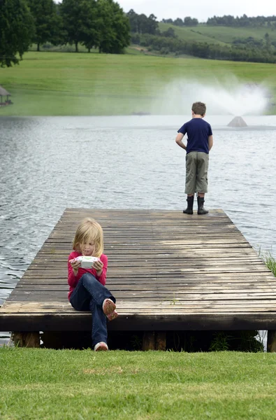 Ung flicka spelar datorspel i naturen — Stockfoto