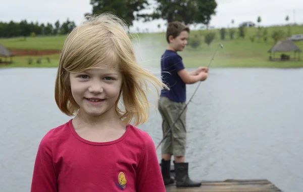 Ung flicka och pojke fiske på träbrygga — Stockfoto