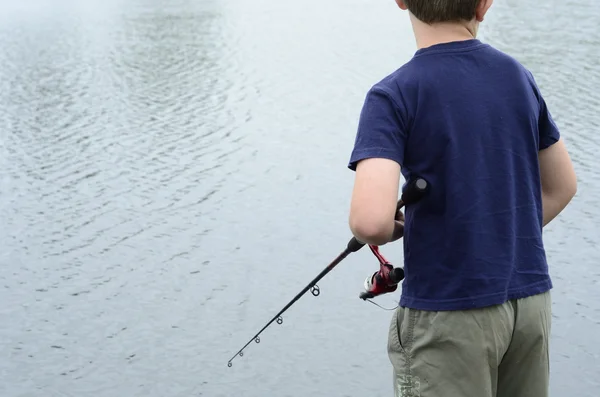Хлопчик риболовля в басовій греблі або озері — стокове фото