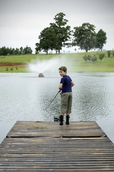 Boy fishing in bass dam or lake — Stock Photo, Image