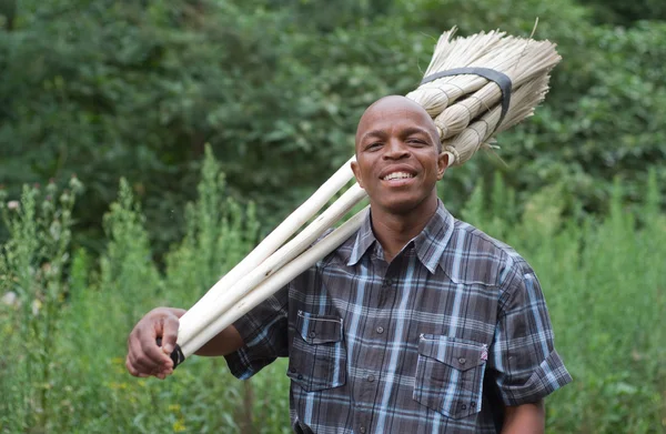 Fotografía de stock del sonriente empresario sudafricano vendedor de escobas para pequeñas empresas — Foto de Stock