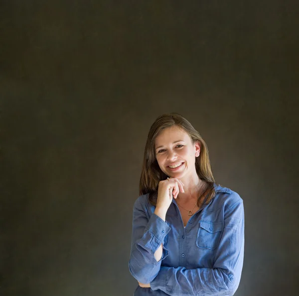 Business woman or teacher with arms crossed against a dark blackboard background — Stock Photo, Image