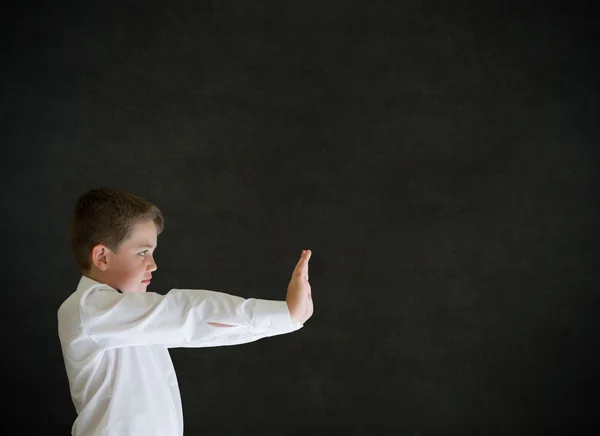 Ragazzo vestito da uomo d'affari spingendo su sfondo lavagna — Foto Stock