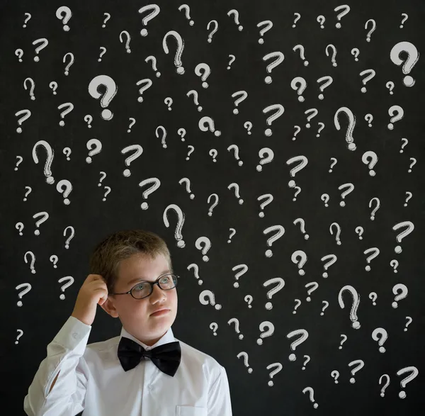Scratching head thinking boy dressed as business man with chalk question marks — Stock Photo, Image