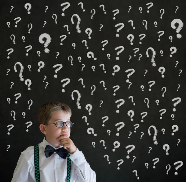 Niño pensante vestido de hombre de negocios con signos de interrogación de tiza —  Fotos de Stock
