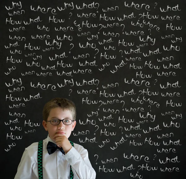 Thinking boy dressed up as business man with chalk questions — Stock Photo, Image