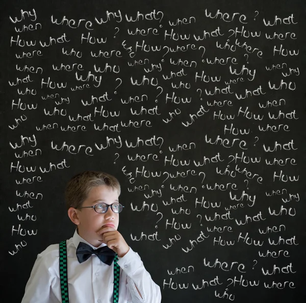 Thinking boy dressed up as business man with chalk questions — Stock Photo, Image