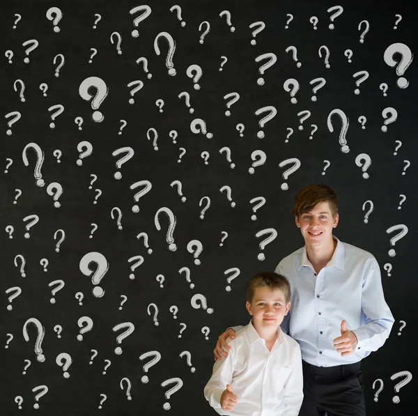 Thumbs up boy dressed up as business man with teacher man and chalk questions marks — Stock Photo, Image