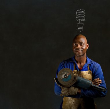 African black man industrial worker with engery saver on blackboard background African black man industrial worker with energy saving lightbulb blackboard clipart
