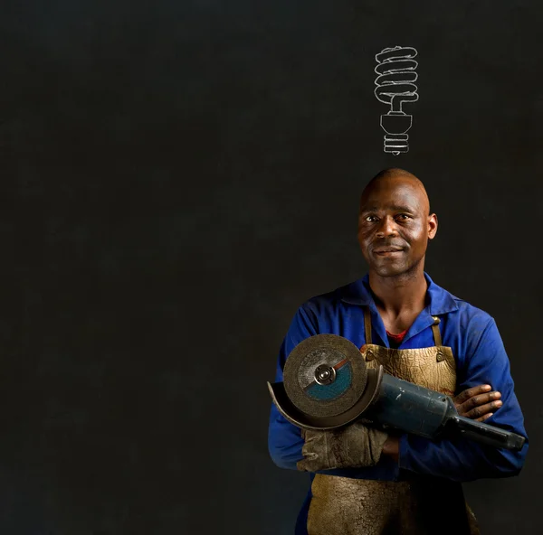 Afrikanischer schwarzer Mann Industriearbeiter mit Energiesparer auf Tafel-Hintergrund Afrikanischer schwarzer Mann Industriearbeiter mit Energiesparlampen-Tafel — Stockfoto