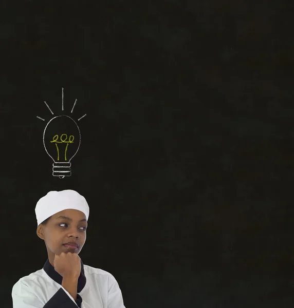 Идея лампочки Африканская женщина шеф-повар на фоне доски мелом — стоковое фото