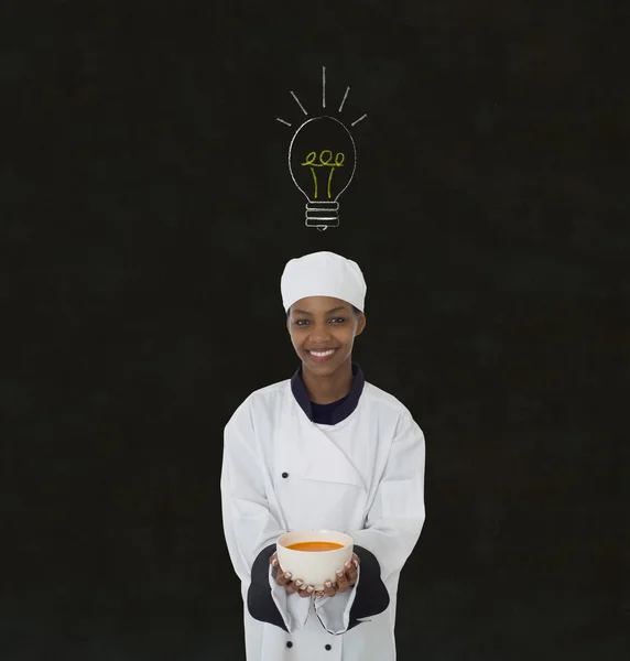 Idea bombilla mujer africana chef en pizarra de tiza fondo — Foto de Stock