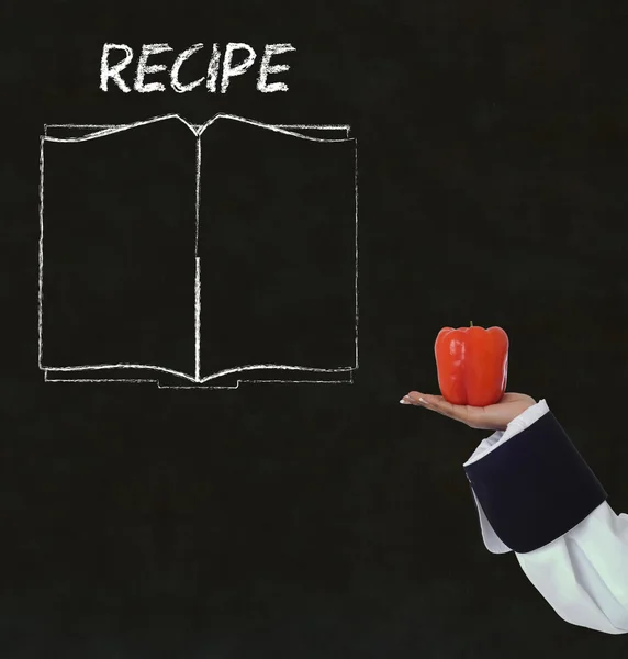 Chef with recipe book on chalk blackboard menu background — Stock Photo, Image