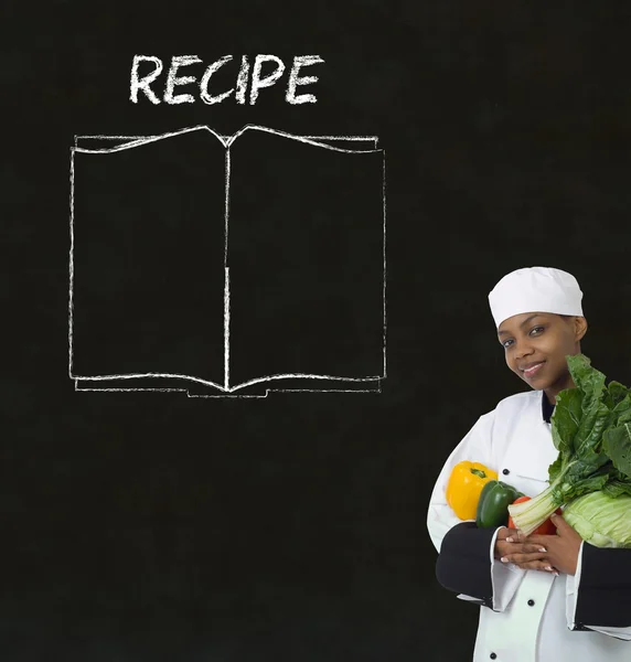 Шеф-повар с книгой рецептов на фоне меню доски мелом — стоковое фото