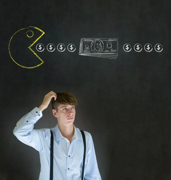 Finansiella affärsman med gul dator spel ikonen äta pengar på blackboard bakgrund — Stockfoto