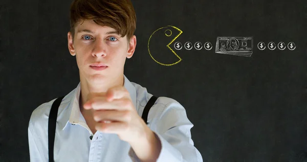 Financial business man with Yellow computer game icon eating money on blackboard background — Stock Photo, Image