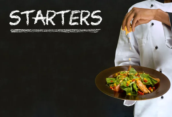 Chef with chalk starters sign on blackboard background — Stock Photo, Image