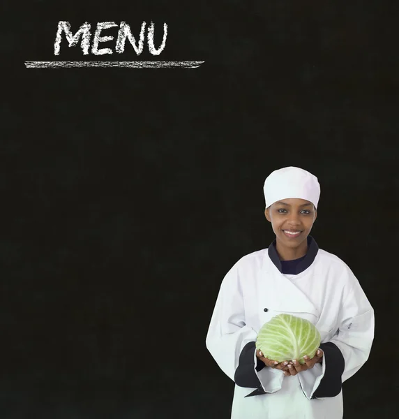 Chef with chalk menu sign on a blackboard background — Stock Photo, Image