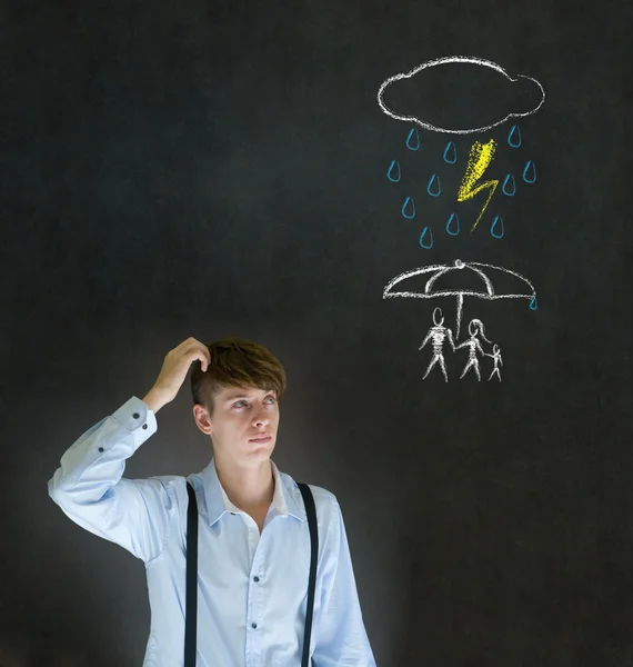 Insurance businessman thinking about protecting family from natural disaster on blackboard background — Stock Photo, Image