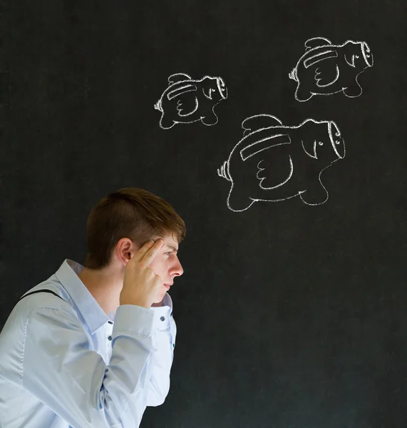 Thinking businessman with flying money piggy banks in chalk on blackboard background — Stock Photo, Image