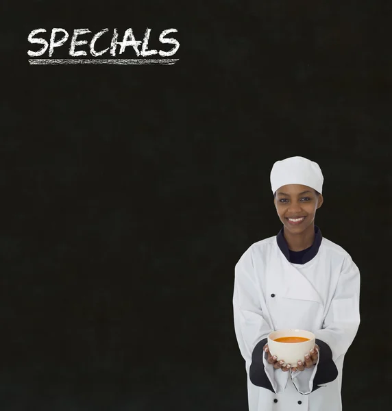 African american kobieta kucharz z kredą znak promocje na tablica tło — Zdjęcie stockowe