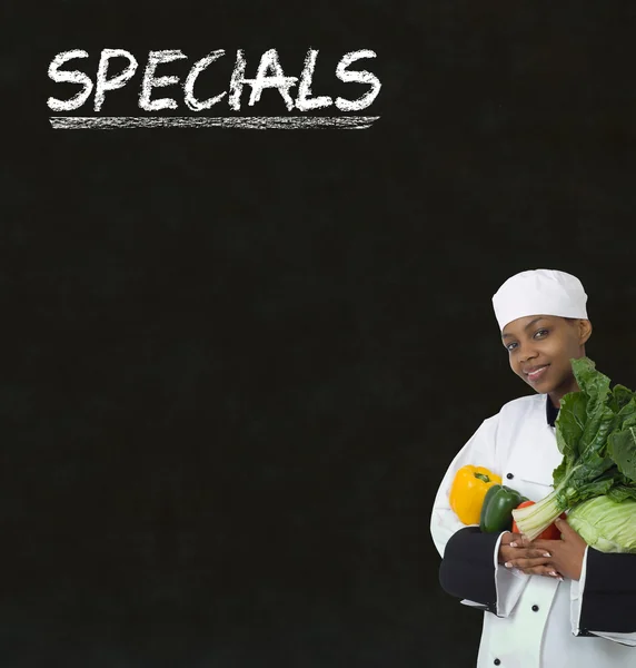 African American woman chef with chalk specials sign on blackboard background — Stock Photo, Image