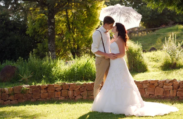 Bride and groom kissing in garden wedding — Stock Photo, Image