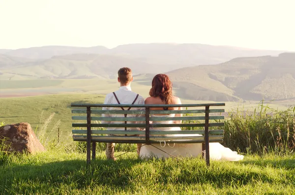 Novia y novio africanos en el banco con el paisaje — Foto de Stock