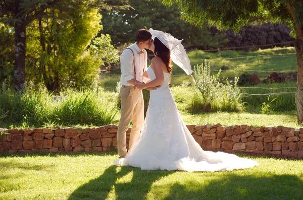 Braut und Bräutigam küssen sich bei Gartenhochzeit — Stockfoto